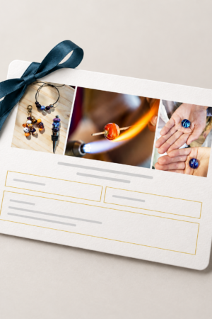 Carte cadeau Audrey SeR avec ruban bleu, illustrée de bijoux, de verre travaillé à la flamme et de perles artisanales.